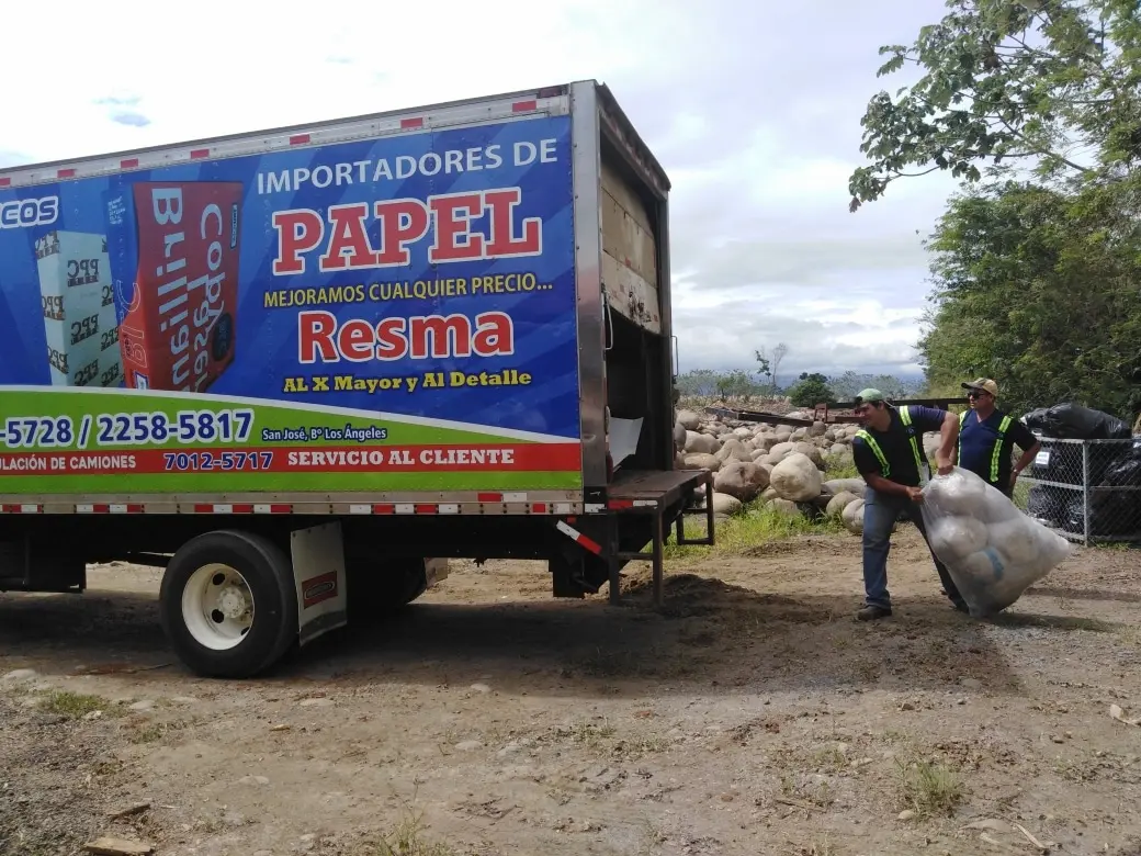 Personal cargando llantas en un camión para reciclaje – Constructora Herrera